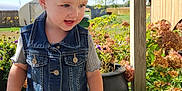 Arya is registered to the contest to win money with this photo: toddler, child, blonde_hair, denim_vest, pink_crocs, flower, porch, wooden_floor, plants, hydrangeas, sunny, outdoor, greenery, blue_sky, curious, casual_clothing, daylight, nature, playful, earrings