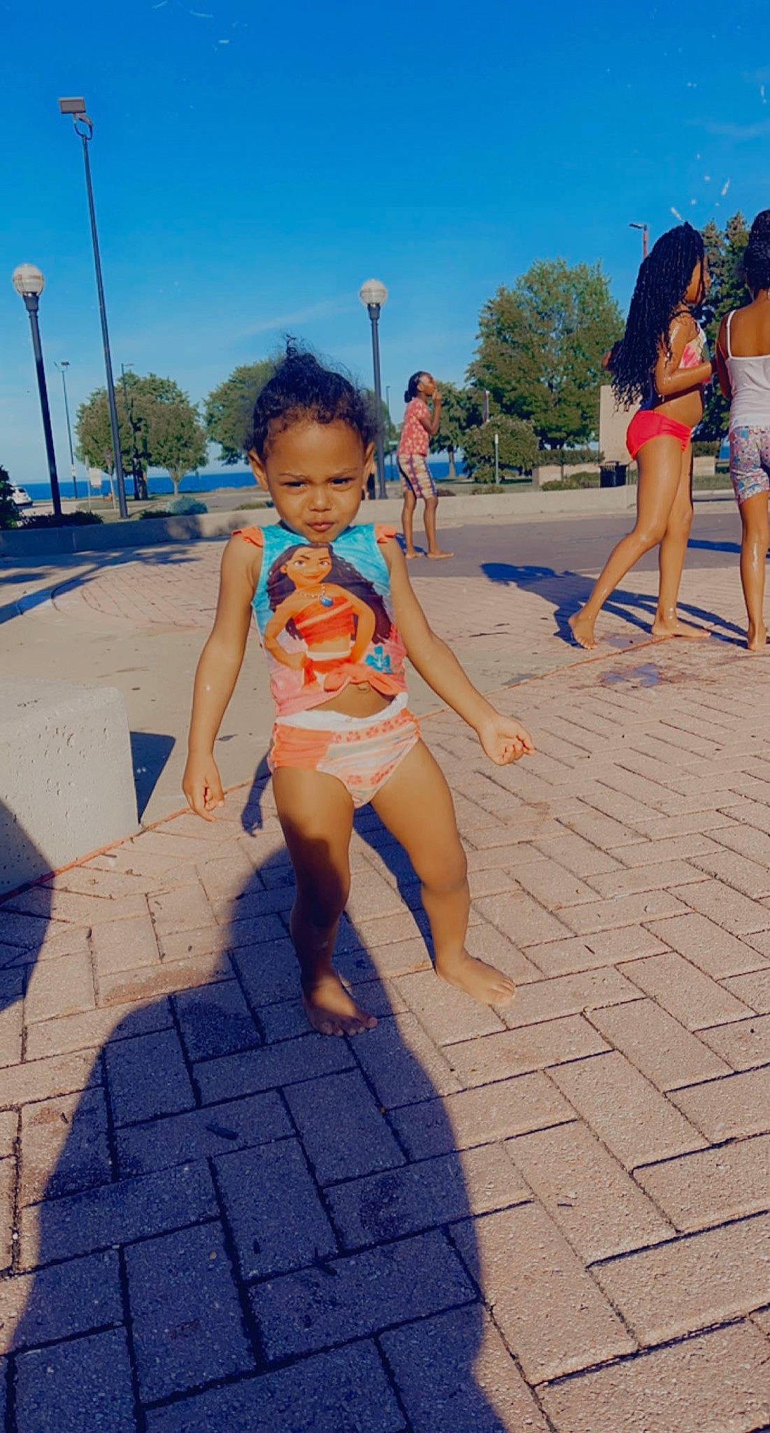 Brooklyn is registered to the contest to win money with this photo: barefoot, brassiere, electric_blue, foot, fun, human_leg, leg, leisure, people_on_beach, person, recreation, sand, shorts, sky, swimming_pool, swimsuit_top, swimwear, thigh, toddler, undergarment