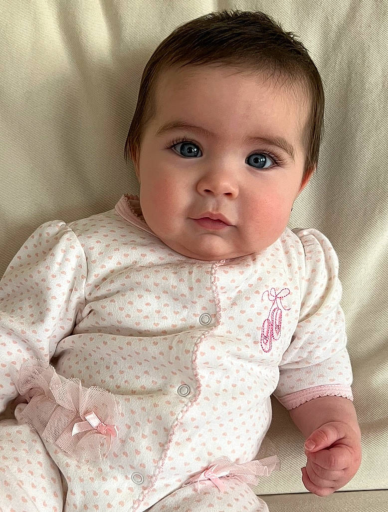 Sloane is registered to the contest to win money with this photo: baby, baby_toddler_clothing, cheek, chin, collar, comfort, eye, eyebrow, eyelash, face, flooring, hairstyle, head, iris, linens, lip, nose, person, skin, sleeve