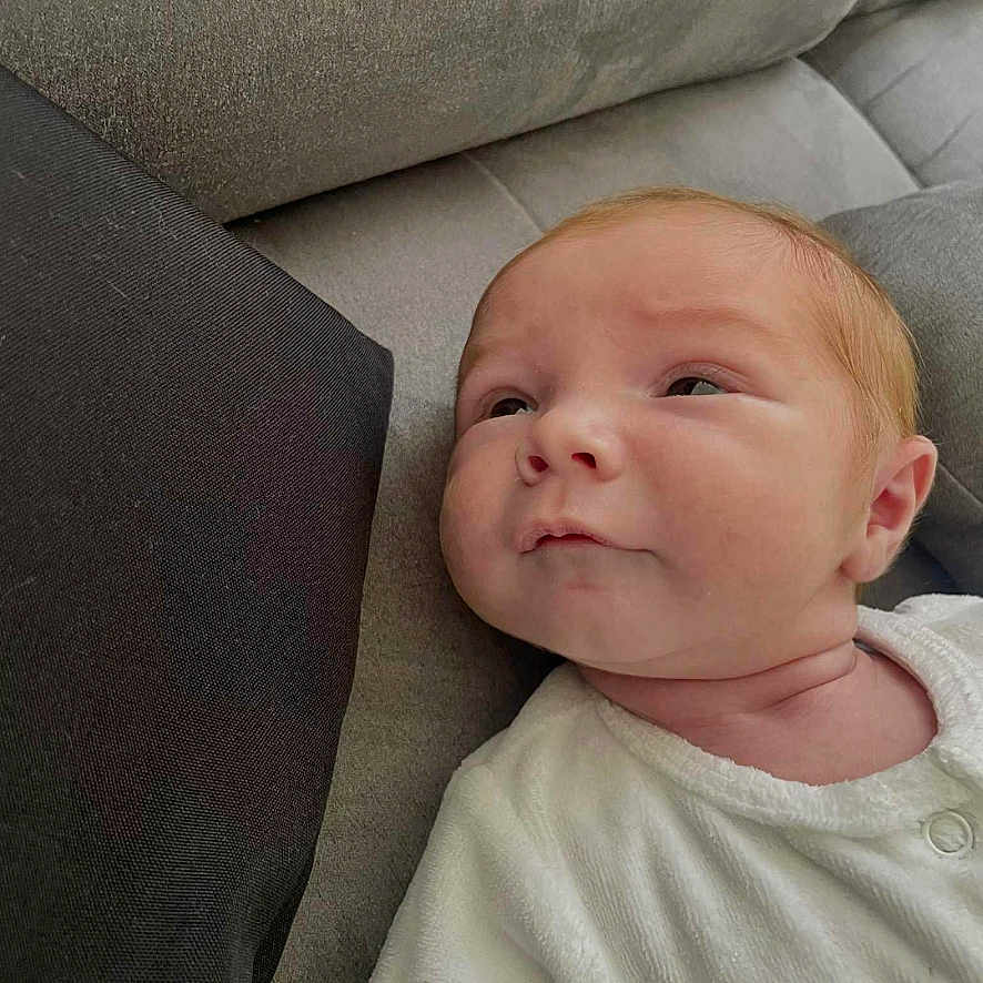 Sam a rejoint le concours — aidez-le/la à gagner de superbes lots ! baby, child, couch, cozy, cute, expression, face, gray, head, indoor, infant, looking, newborn, person, portrait, resting, skin, soft_texture, white_clothing, young_child