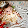 baby, child, infant, bow, yellow_dress, blanket, numbers, floor, colorful, pattern, cute, reaching, blue_eyes, portrait, indoors, soft_light, person, young_child, playful, toddler