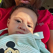 Rhythm joined the competition — help win amazing prizes! child, baby, person, face, mickey_mouse, cartoon, clothing, red_shirt, curly_hair, portrait, indoors, sunlight, expression, closeup, cuddling, adult, casual, car_seat, toddler, cute