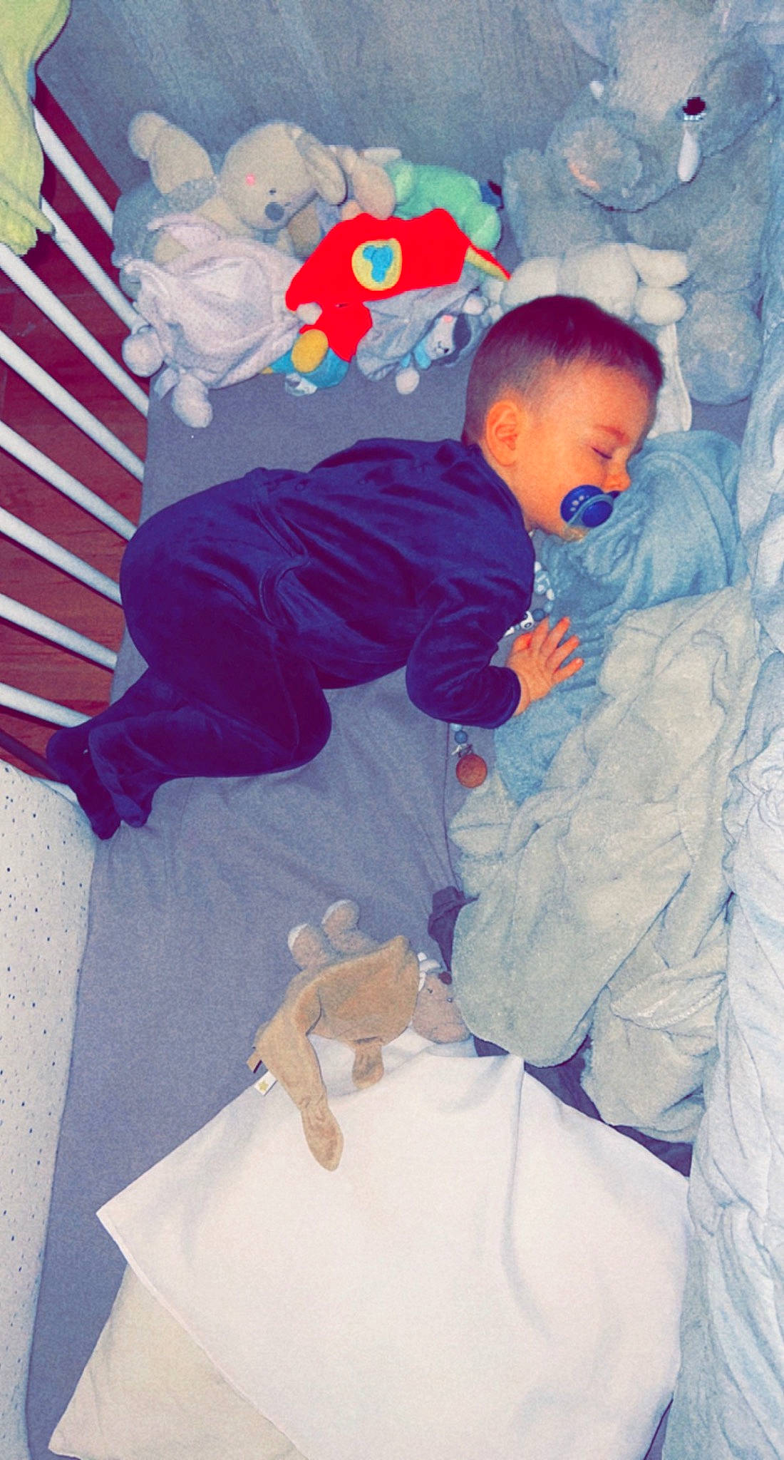 Tino a rejoint le concours — aidez-le/la à gagner de superbes lots ! baby, baby_products, baby_sleeping, baby_toddler_clothing, carmine, child, comfort, electric_blue, fictional_character, fun, happy, linens, person, play, room, sitting, sleeve, stuffed_toy, t_shirt, toddler