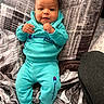 Kassio joined the competition — help win amazing prizes! baby, child, infant, blue_clothing, sweatshirt, pants, socks, pillow, blanket, fabric, pattern, indoor, smiling, cute, portrait, person, cozy, relaxed, casual_wear, home