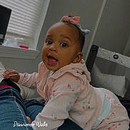 Dionne joined the competition — help win amazing prizes! baby, child, toddler, pink_clothing, bow, indoor, window_blind, crib, jeans, legs, person, playful, curious, smiling, face, head, crawling, home, cozy, casual