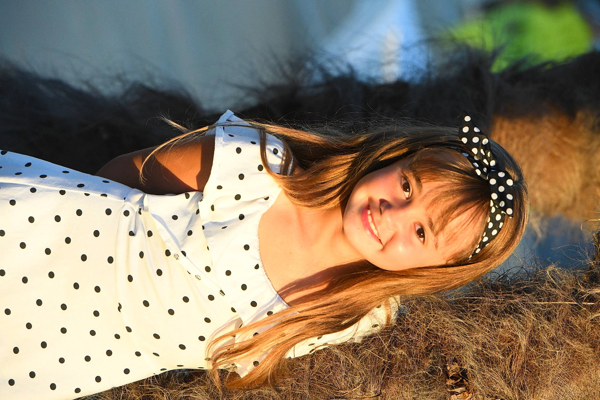 Emma a rejoint le concours — aidez-le/la à gagner de superbes lots ! black_hair, brown_hair, child, dress, fawn, flash_photography, fun, grass, grassland, happy, human_leg, joy, landscape, lip, long_hair, people_in_nature, person, plant, sitting, smile