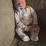 baby, sleeping, pacifier, onesie, crab_pattern, couch, furniture, cozy, infant, child, nap, relaxing, indoor, soft_lighting, peaceful, cute, person, seated, resting, comfortable
