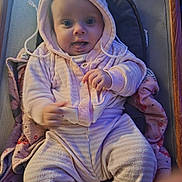Ariella is registered to the contest to win money with this photo: baby, child, hoodie, blanket, cushion, chair, indoor, smiling, tongue_out, sitting, cute, infant, warm_clothing, person, soft_lighting, cozy, plush, face, portrait, happy