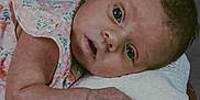 Ariella is registered to the contest to win money with this photo: baby, basket, blanket, closeup, clothing, curious, expression, eyes, fabric, face, hand, head, indoor, infant, laying_down, person, portrait, skin, soft_lighting, young_child