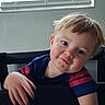 child, boy, toddler, portrait, smiling, happy, playful, face, blue_eyes, blond_hair, short_hair, striped_shirt, navy_shirt, red_stripes, sitting, chair, indoor, window, blinds, natural_light