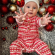 Elizabeth Kopylova is registered to the contest to win money with this photo: baby, child, infant, christmas, holiday, santa_hat, pajamas, red, white, ornaments, decorations, festive, reaching, hands, face, eyes, floor, patterned, celebration, cute