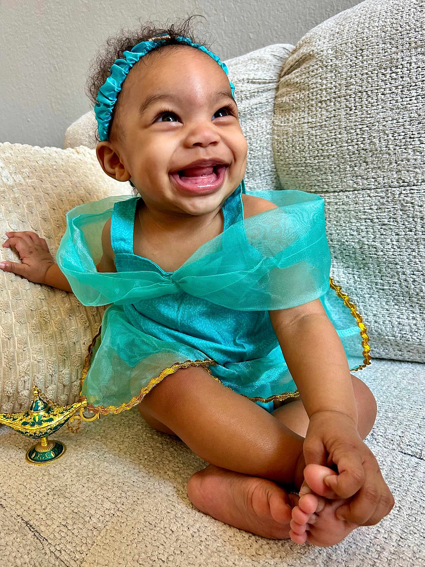 Zuri Isabella joined the competition — help win amazing prizes! toddler, child, smiling, happy, dress, headband, couch, indoor, toy, genie_lamp, barefoot, crossed_legs, cute, portrait, young_child, joyful, skin, hand, feet, fabric