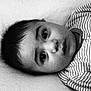 baby, black_and_white, child, close_up, curious_eyes, cute, expressionless, face, head, indoors, infant, lying_down, monochrome, newborn, person, portrait, sleepwear, soft_lighting, striped_clothing, young_child