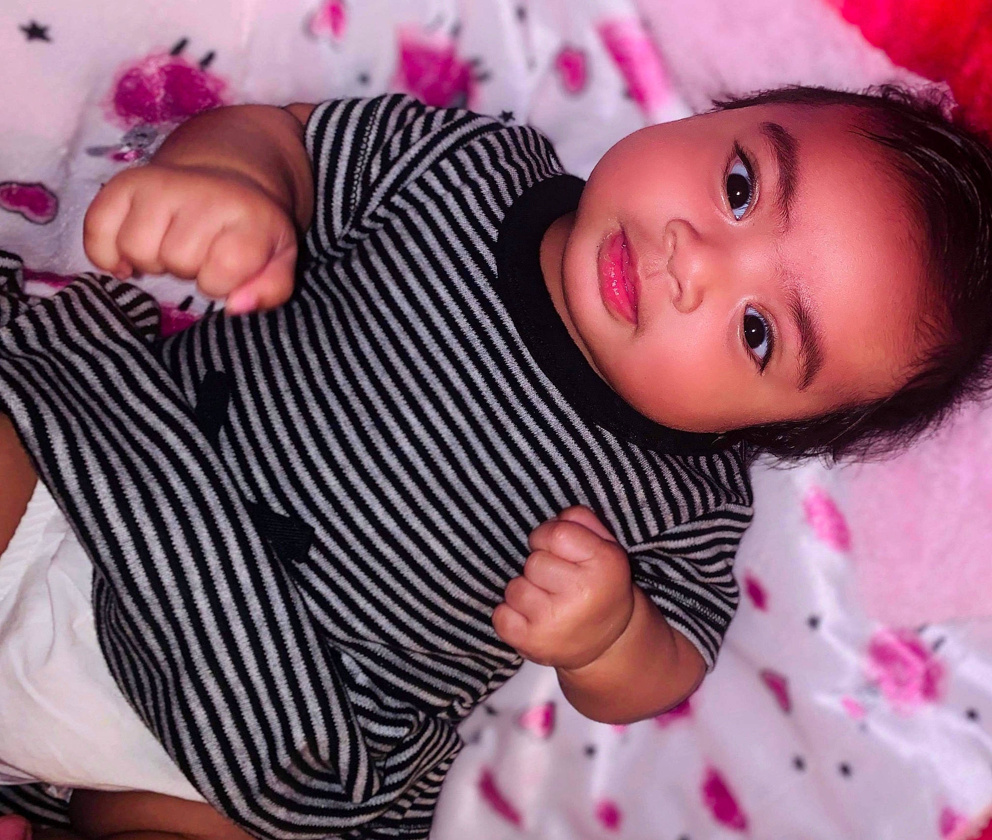 Dlovea Oloday is registered to the contest to win money with this photo: arm, baby, baby_toddler_clothing, cheek, dress, eye, eyelash, finger, gesture, hand, happy, iris, lip, nose, person, pink, skin, sleeve, textile, toddler