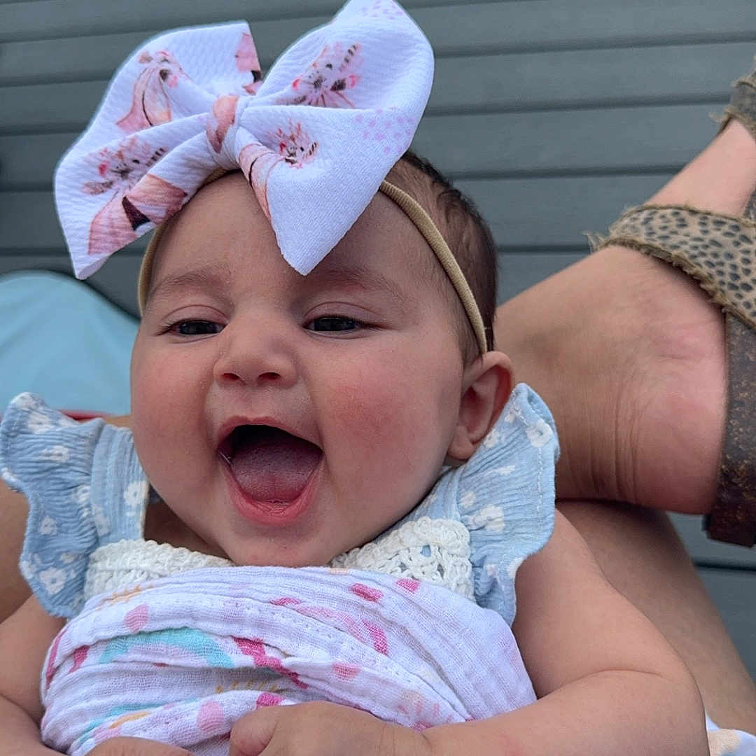 Mikiah is registered to the contest to win money with this photo: accessories, baby, blanket, clothing, cushion, dress, face, furniture, grass, happy, hat, head, homedecor, laughing, newborn, person, photography, plant, portrait, quilt