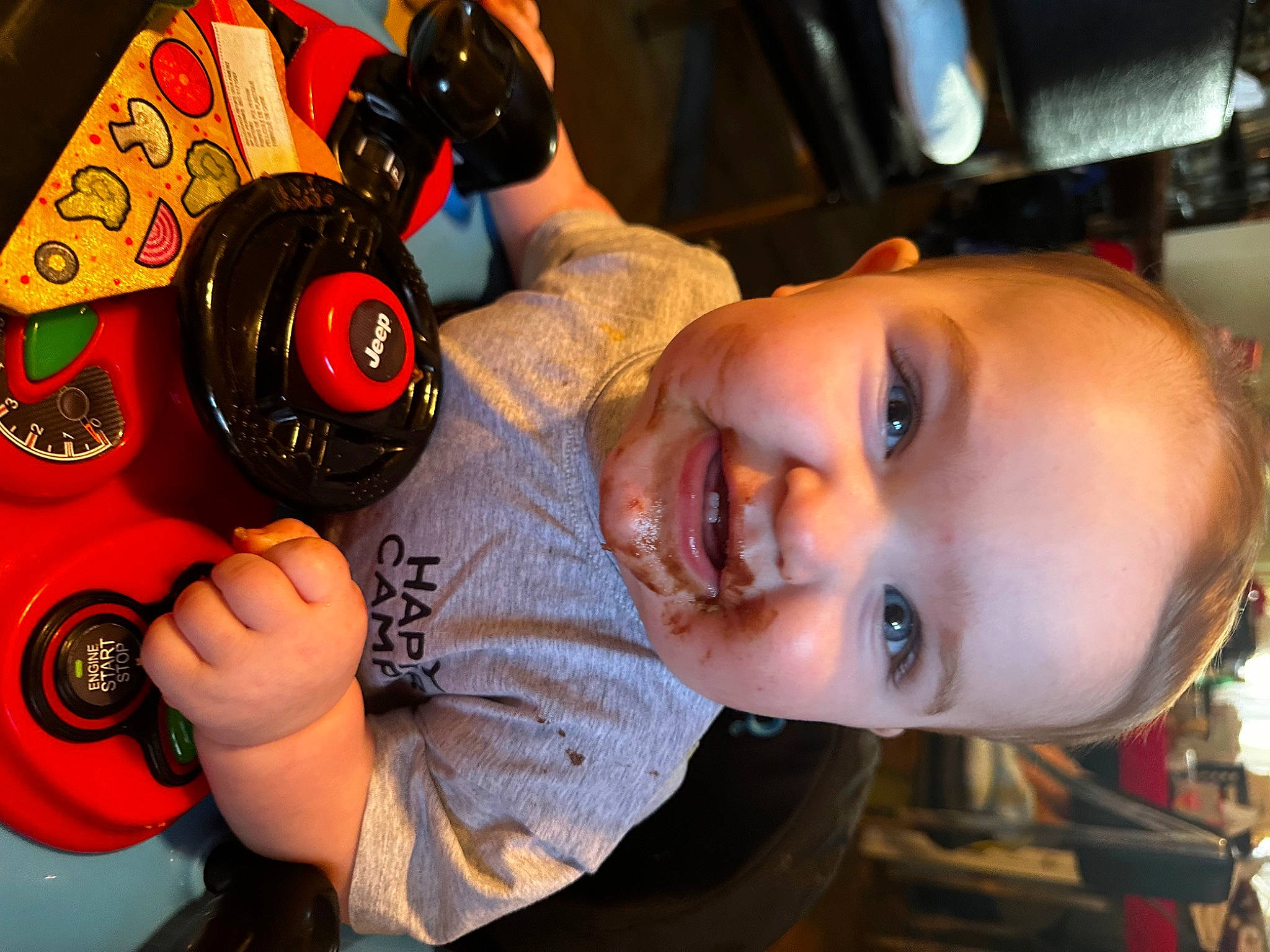 Malakai is registered to the contest to win money with this photo: auto_part, automotive_lighting, automotive_tire, automotive_wheel_system, baby, carmine, child, drink, fun, happy, joy, mouth, nose, person, personal_protective_equipment, smile, sports_gear, steering_wheel, tire, toddler