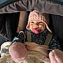 baby, baby_clothes, blanket, bundle_up, child, cozy, cute, face, happy, indoor, infant, mittens, pacifier, pink_hat, polka_dot, smiling, soft_toys, stroller, warm, winter_clothing