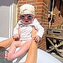 arms, baby, brick_wall, cute, foot, hands, head_wrap, infant, outdoor, person, pool, posing, shadows, skin, summer, sunglasses, sunlight, water, white_clothing, wooden_planter