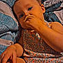 toddler, child, baby, pacifier, bed, blanket, patterned_blanket, floral_dress, blue_eyes, indoor, relaxed, cute, person, skin, hand, face, infant, resting, young_child, cozy