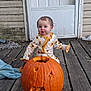 Blakeleigh Fisher is registered to the contest to win money with this photo: baby, child, toddler, pumpkin, jack_o_lantern, wooden_porch, door, pajamas, sunflower_pattern, fall, autumn, outdoor, person, face, smiling, curly_hair, door_handle, wood, seasonal, holiday