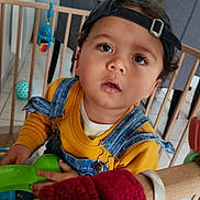 Noa participe au concours pour gagner de l'argent avec cette photo : baby_toys, cap, casual, chair, child, clothing, curious, denim_overalls, expression, face, floor, furniture, headwear, home, indoor, person, playpen, toddler, toy, young_child