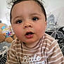 Noa a rejoint le concours — aidez-le/la à gagner de superbes lots ! baby, child, curly_hair, striped_shirt, text_on_clothing, indoor, bed, blanket, toys, stuffed_animal, portrait, face, cute, young_child, person, expression, soft_lighting, closeup, comfort, sleepwear