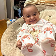 Lucas joined the competition — help win amazing prizes! baby, infant, smile, pajamas, crab_pattern, baby_chair, plush, indoor, happy, cute, child, person, cozy, toothy_grin, comfortable, clothing, footed_pajamas, furniture, home, relaxed