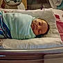 newborn, baby, sleeping, hospital, bassinet, blanket, swaddled, medical_tube, crib, bed, infant, person, resting, indoors, healthcare, pink, white, blue, soft, quiet