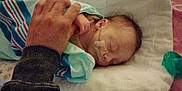 Brooklyn joined the competition — help win amazing prizes! baby, sleeping, hand, hospital_blanket, nasal_tube, pillow, infant, bed, person, healthcare, care, newborn, resting, soft_lighting, wrapped, blanket, adult_hand, tenderness, closeup, indoors