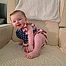 baby, infant, child, smiling, cute, armchair, clothing, romper, stars, stripes, red, white, blue, happy, skin, foot, hand, indoor, cozy, portrait
