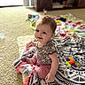 Emily is registered to the contest to win money with this photo: baby, child, smiling, indoor, blanket, toy, carpet, floor, person, clothing, pattern, colorful, happy, sitting, cute, infant, home, young, playful, comfort