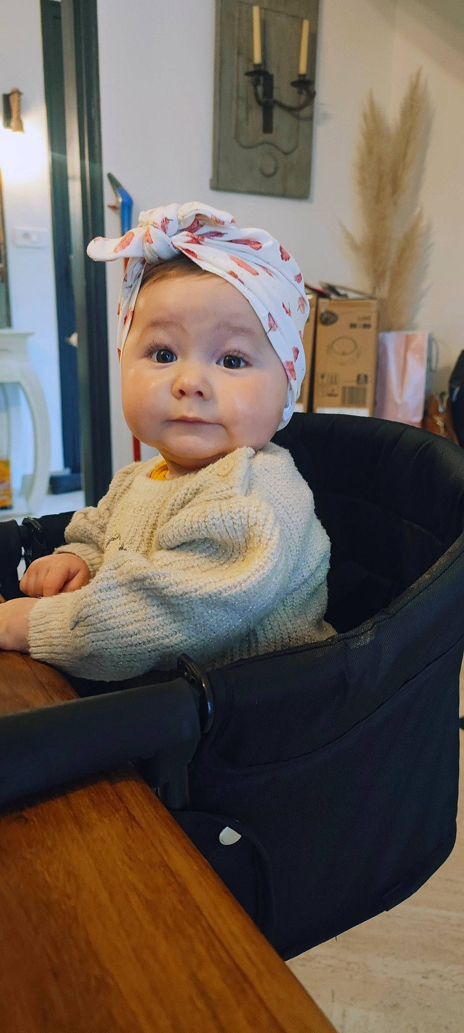 Lya a rejoint le concours — aidez-le/la à gagner de superbes lots ! baby, baby_toddler_clothing, beanie, cap, chair, cheek, child, comfort, fashion_accessory, headwear, person, room, sitting, sleeve, table, toddler, wood, wool