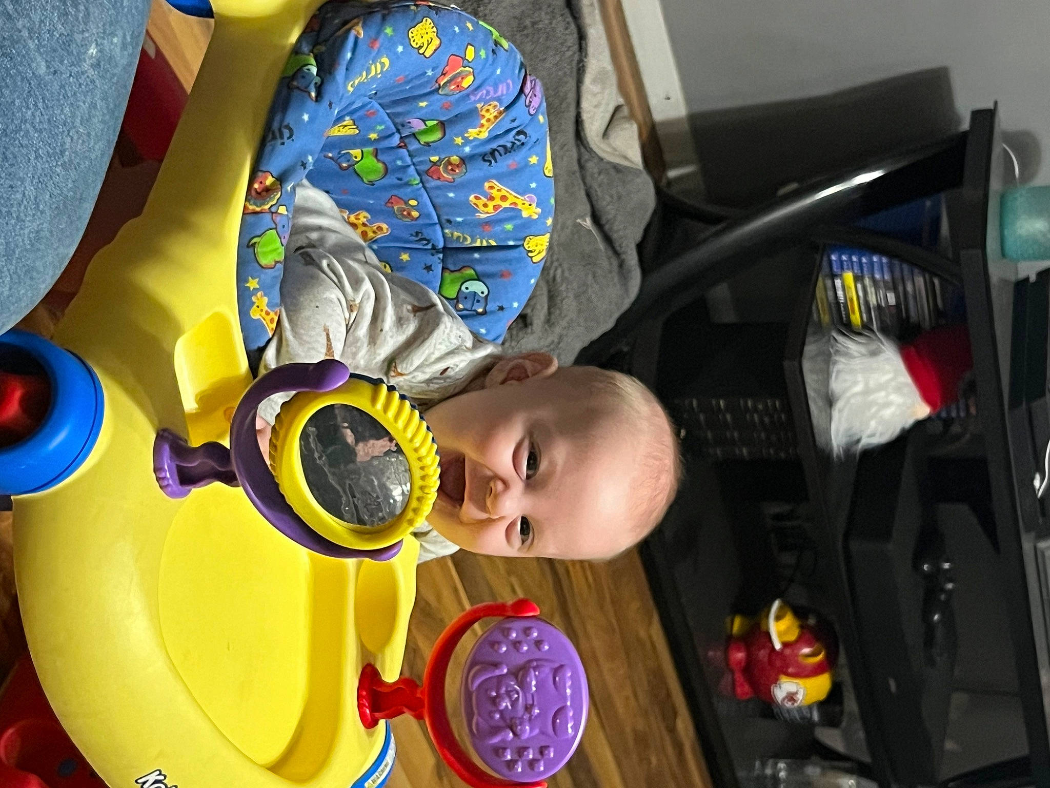 Waylon is registered to the contest to win money with this photo: auto_part, automotive_wheel_system, baby, baby_products, baby_toys, chair, child, circle, electric_blue, fictional_character, fun, happy, hat, person, personal_protective_equipment, play, recreation, room, toddler, toy