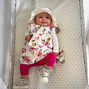 Juliette a rejoint le concours — aidez-le/la à gagner de superbes lots ! baby, infant, crib, floral_dress, hat, pink_leggings, boots, face, tongue_out, patterned_bedding, mesh_sides, cute, child, lying_down, playful, indoors, person, apparel, footwear, smiling