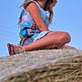 child, girl, hat, straw_hat, dress, sandals, hay, outdoor, sky, summer, portrait, sitting, nature, happy, cute, looking_away, field, daytime, casual, relaxed