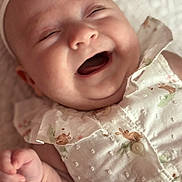 Bailey is registered to the contest to win money with this photo: baby, infant, smiling, laughing, face, headband, clothing, white_outfit, bunny_prints, cute, happy, closeup, skin, hand, fingers, lying_down, blanket, soft_texture, child, portrait