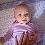 Harmony is registered to the contest to win money with this photo: baby, infant, hand, purple_clothing, blanket, face, blue_eyes, person, skin, nail_polish, ring, holding_hand, lying_down, portrait, close_up, soft_texture, indoor, cute, expression, child