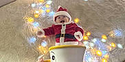 Malo participe au concours pour gagner de l'argent avec cette photo : baby, child, christmas, cute, decor, fairy_lights, festive, floor, hand, holiday, indoor, person, red, rug, santa_costume, smiling, teacup, toy, white, yellow