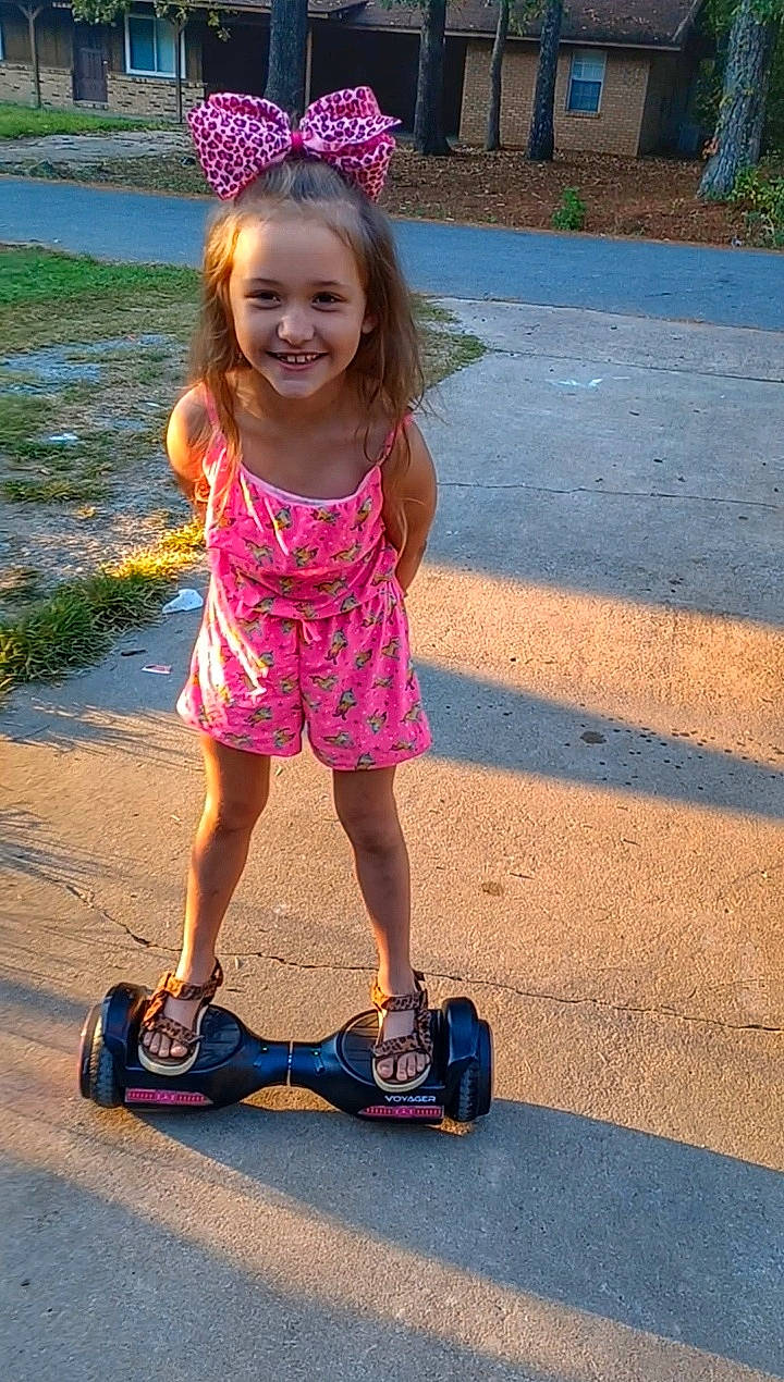 Adelyn is registered to the contest to win money with this photo: asphalt, child, electric_blue, fun, grass, happy, helmet, jewellery, joy, leisure, magenta, person, pink, public_space, purple, recreation, rolling, shorts, smile, sports_equipment