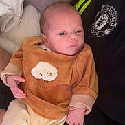 Nayel participe au concours pour gagner de l'argent avec cette photo : baby, newborn, infant, onesie, sleepsuit, couch, blanket, holding, hand, face, portrait, young_child, cute, clothing, plush_patch, manchester_united_logo, jersey, sofa, indoor, parent_arm