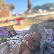 Sierrah participe au concours pour gagner de l'argent avec cette photo : baby, beach, blanket, child, clothing, cute, daytime, hat, infant, lying_down, outdoor, pacifier, portrait, relaxing, sand, summer, sunhat, sunny, toy, vacation