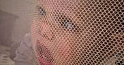 Eleanor joined the competition — help win amazing prizes! baby, child, closeup, clothing, curious, expression, eyes, face, head, indoor, infant, mesh, mouth, netting, pattern, person, playpen, skin, soft_light, texture