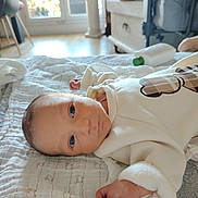 Silaé a rejoint le concours — aidez-le/la à gagner de superbes lots ! baby, newborn, infant, face, eyes, hand, blanket, onesie, bed, lotion_bottle, window, sunlight, indoor, home, furniture, portrait, closeup, laying_down, soft_texture, cute
