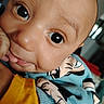 baby, big_eyes, candid, cartoon_print, cheek, close_up, clothing, cute, eyelashes, fabric, hand, head, indoors, infant, mouth, nose, portrait, skin, smile, sweater