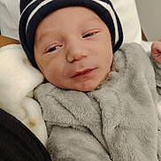 Silaé participe au concours pour gagner de l'argent avec cette photo : arm, baby, beanie, bed, blanket, cheeks, clothing, cozy, eyes_half_closed, face, fuzzy_clothing, hand, hat, infant, newborn, pillow, portrait, sleepy, small_person, soft_texture