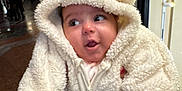 Eline a rejoint le concours — aidez-le/la à gagner de superbes lots ! baby, child, infant, cute, fluffy_clothing, hooded_onesie, bear_ears, indoor, portrait, person, warm_clothing, expression, curious, soft_texture, close_up, face, candid, adorable, young, smiling