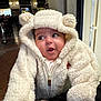 baby, child, infant, cute, fluffy_clothing, hooded_onesie, bear_ears, indoor, portrait, person, warm_clothing, expression, curious, soft_texture, close_up, face, candid, adorable, young, smiling
