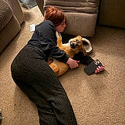 Ember joined the competition — help win amazing prizes! person, dog, carpet, indoor, couch, hugging, smartphone, brown, relaxed, furniture, floor, casual_clothing, pet, cozy, resting, companion, home, carpeted_floor, interaction, warm_lighting