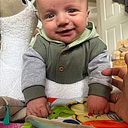 Aaron joined the competition — help win amazing prizes! baby, bird_toy, blue_eyes, child, clothing, couch, cute, door, face, fist, furniture, hand, hoodie, indoor, infant, person, play_mat, plush_toy, smiling, toy