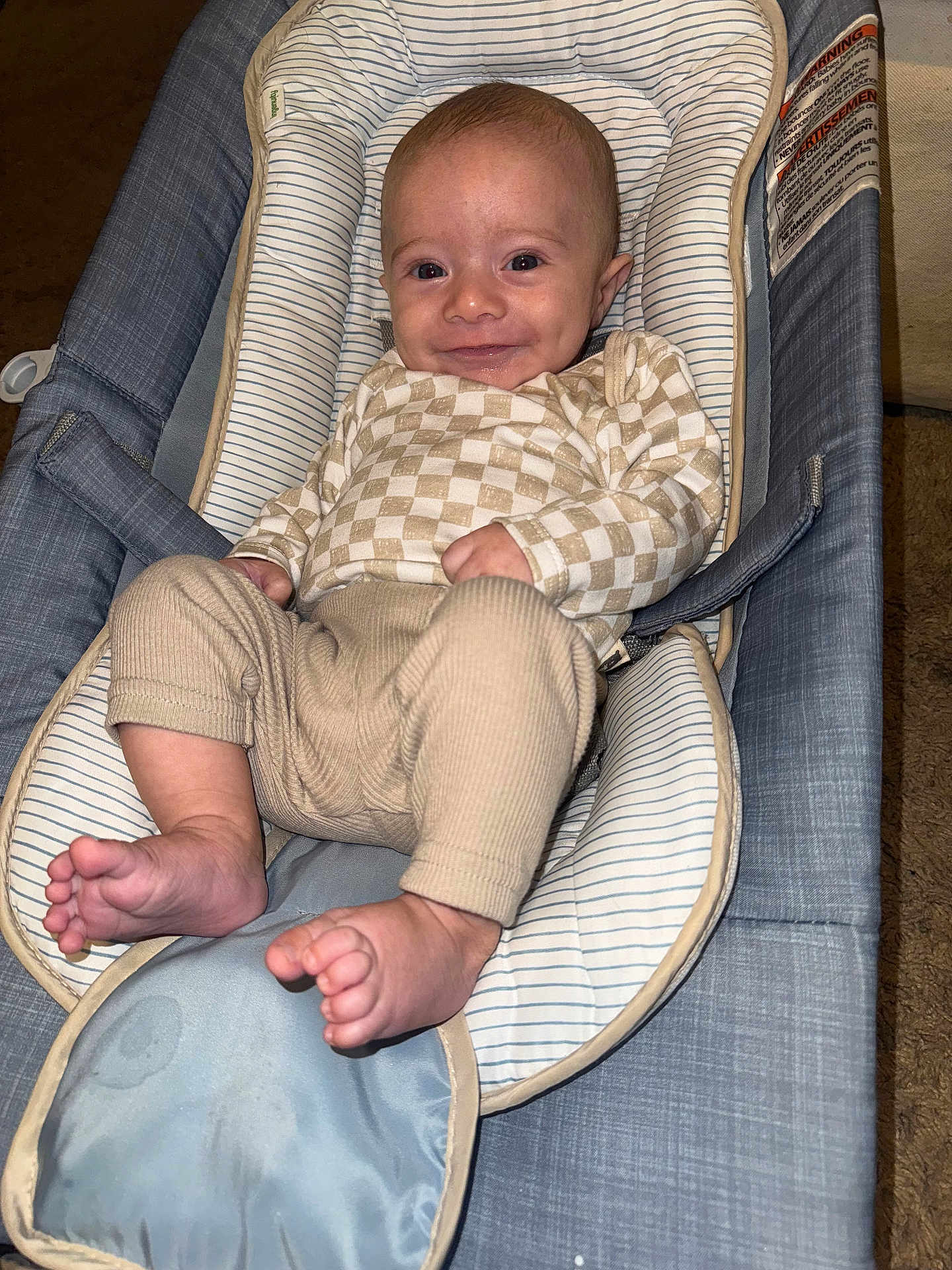 Cooper joined the competition — help win amazing prizes! baby, infant, smile, baby_seat, clothing, checkered_pattern, foot, hand, face, cushion, fabric, indoor, comfort, child, person, cute, relaxing, happy, skin, head